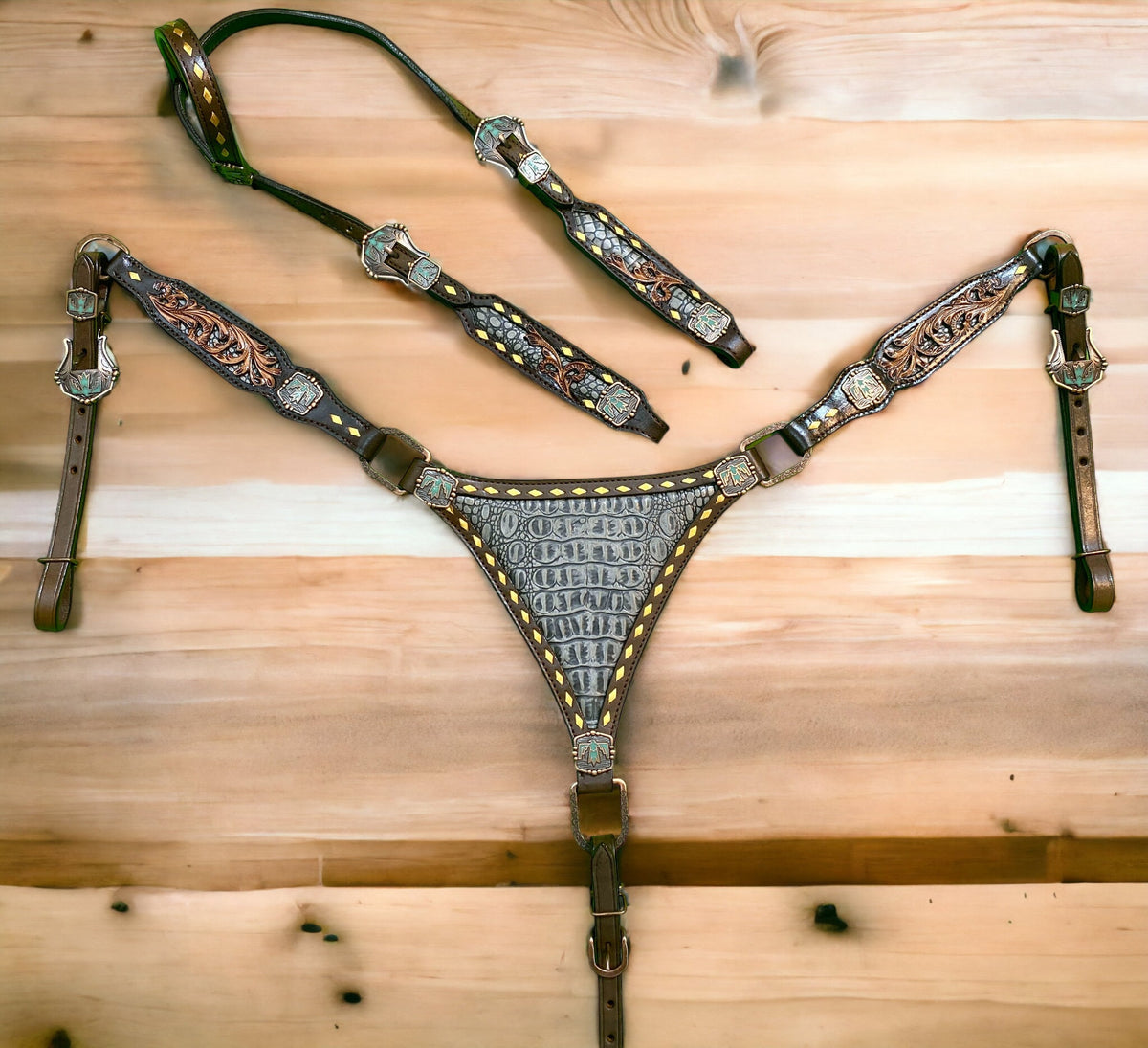 A set of Argentina cow leather Western horse tack, featuring a breast collar and headstall with grey alligator and filigree carving, and thunderbird hardware.