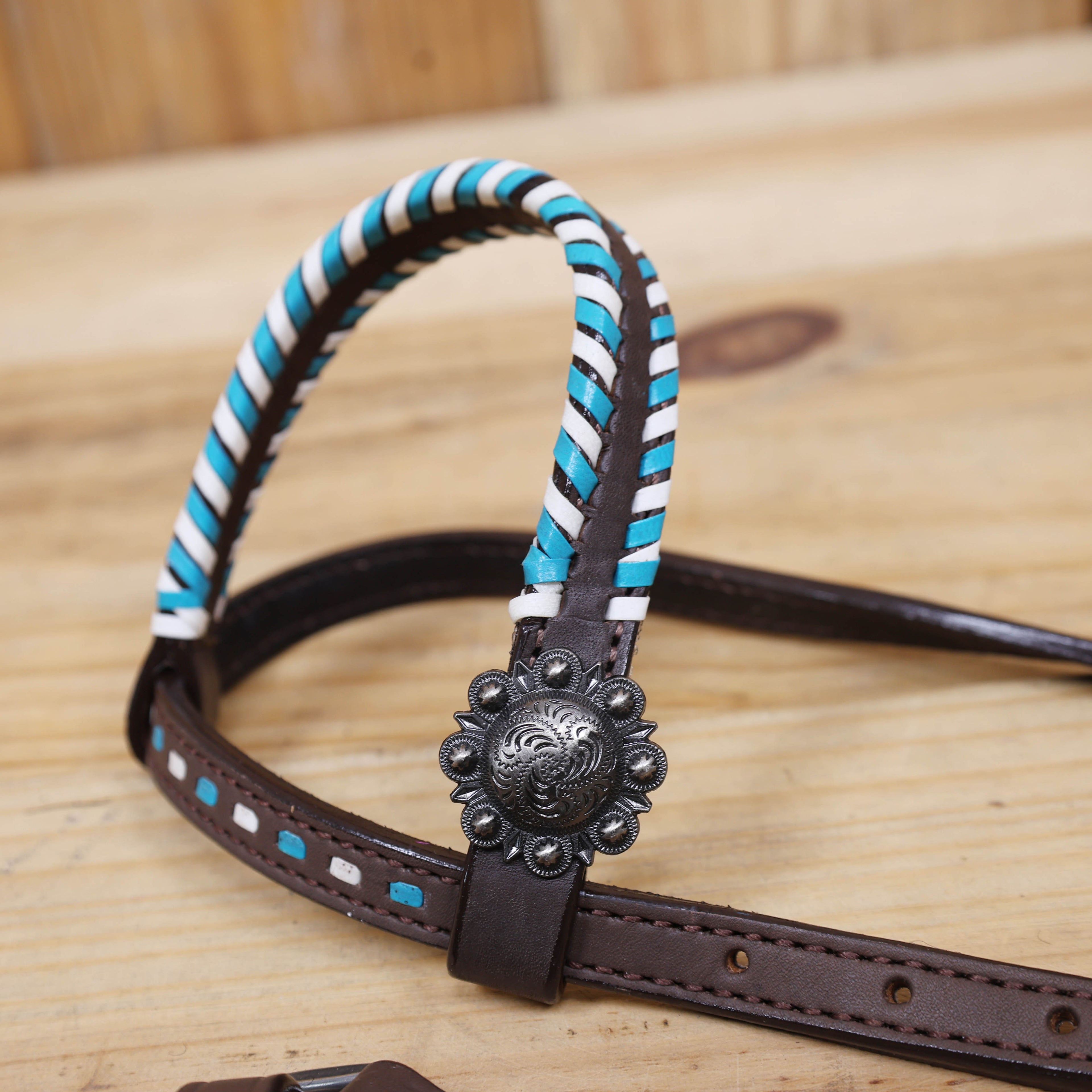 Western horse tack set with arrow style rawhide braiding and whip stitching with berry Conchos