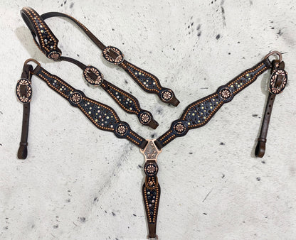 A set of Western horse tack including a headstall and breast collar with black rhinestone accents and copper colored hardware, displayed on a light background.