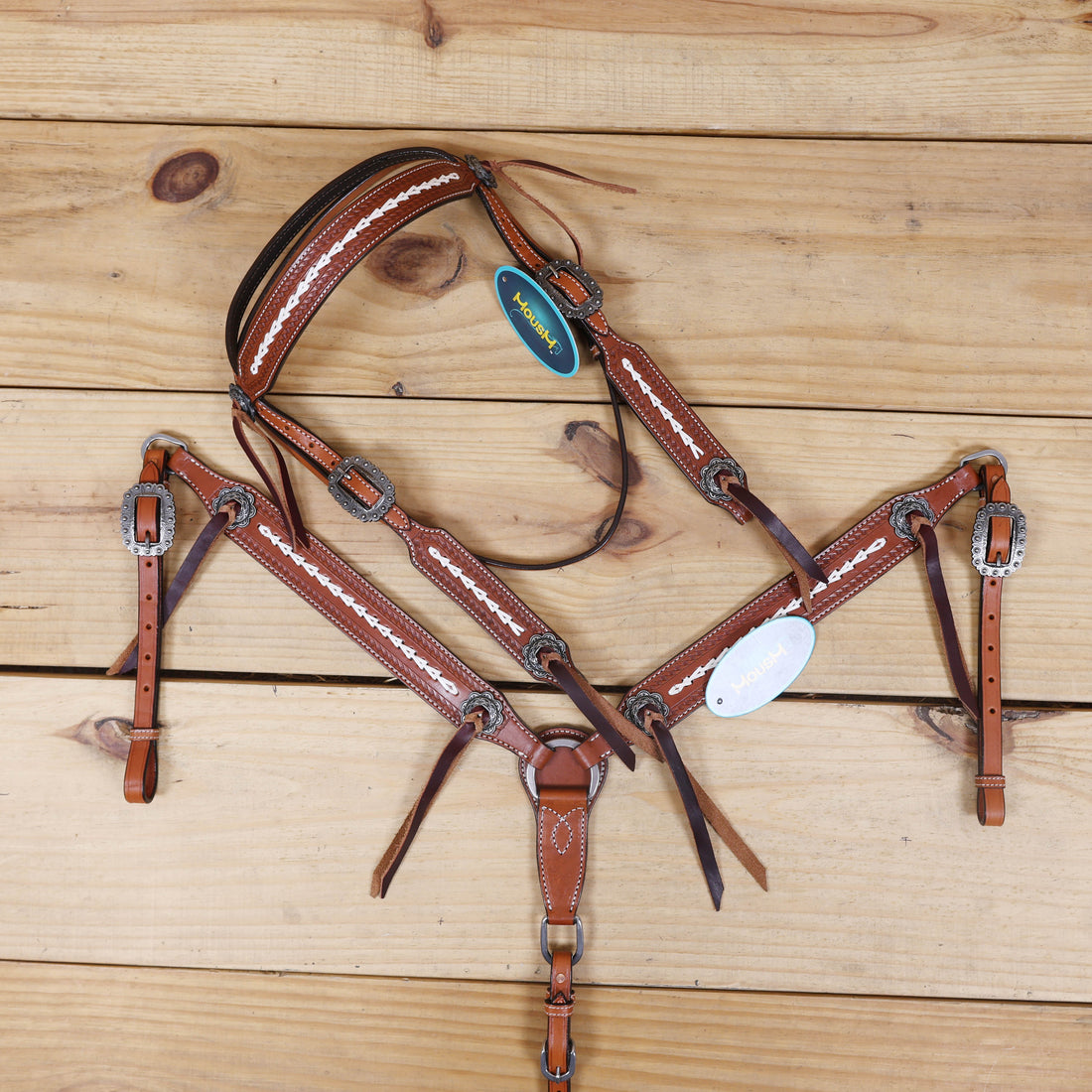 western leather headstall and breast collar set with burgundy leashes and basket tooling