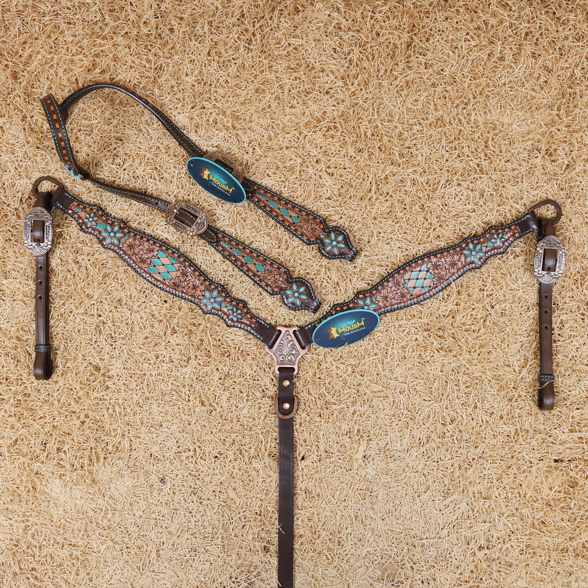 A set of Argentina cow leather Western tack, including a headstall and breast collar, with hand-painted floral and geometric detailing, copper rawhide braiding, and antique copper hardware.