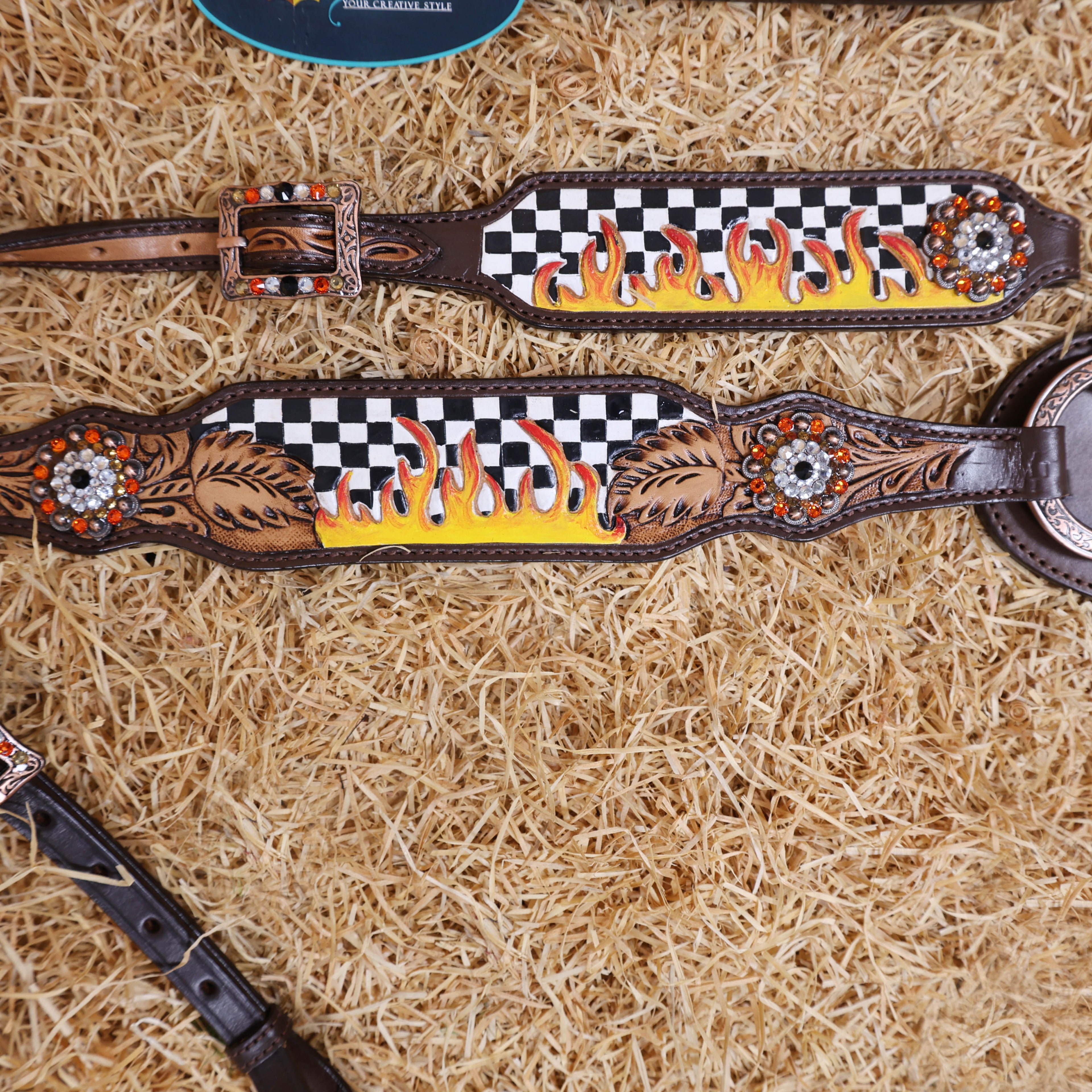 Decorative headstall with checkered pattern and flame design on a hay background