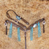 A set of Argentina cow leather Western horse tack including a bridle and breast collar with 3D croc print, turquoise fringe, copper studs, and antique copper hardware, displayed on a bed of straw.