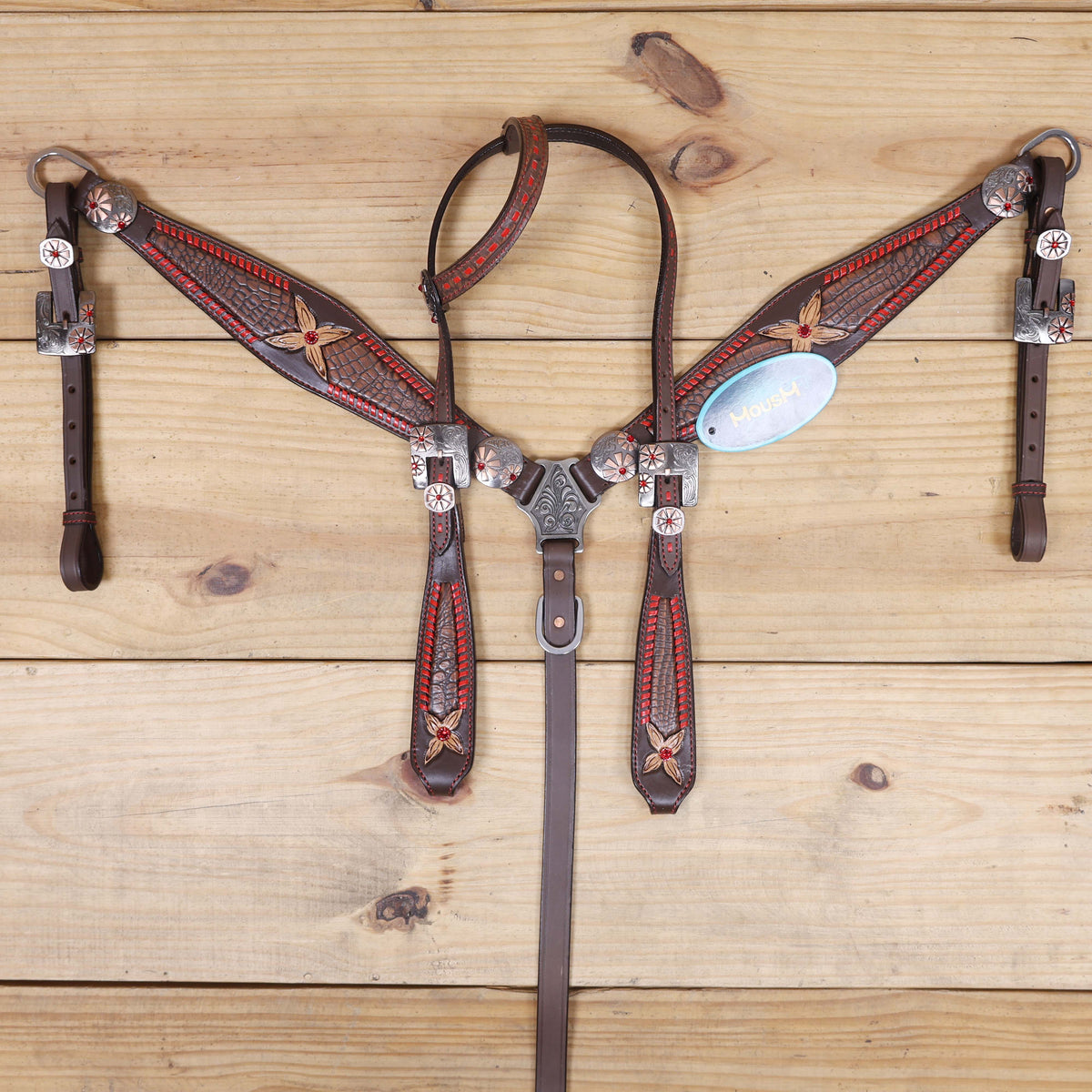 western horse tack set with red rawhide whip stitching and two-tone conchos