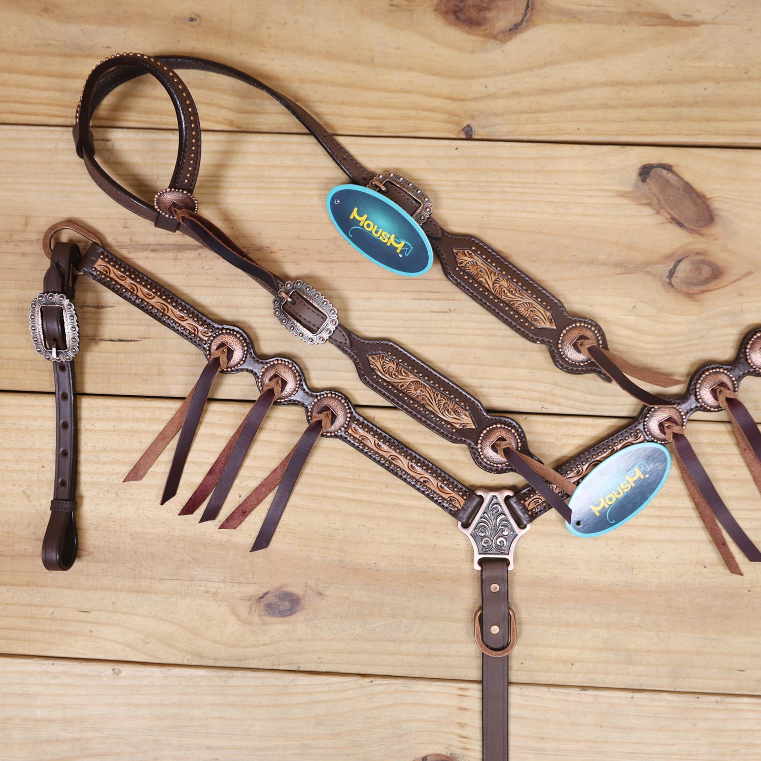 Western riding tack set with hand-carved border design matching slot conchos and rustic copper trim