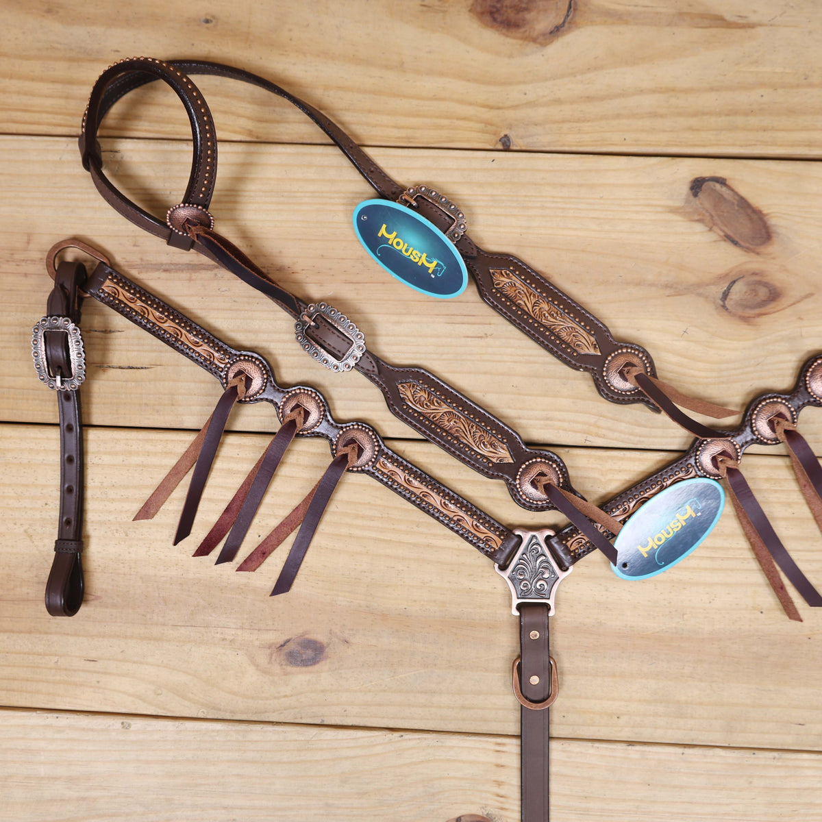 Western riding tack set with hand-carved border design matching slot conchos and rustic copper trim