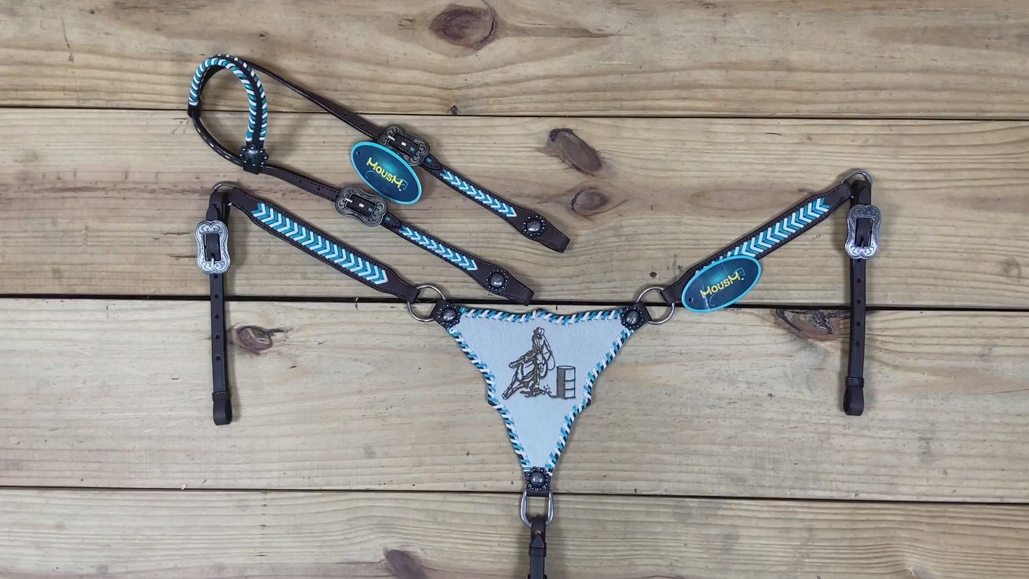 Western horse tack with teal and white rawhide braiding, gladiator style breast collar, and artisan racer engraving details