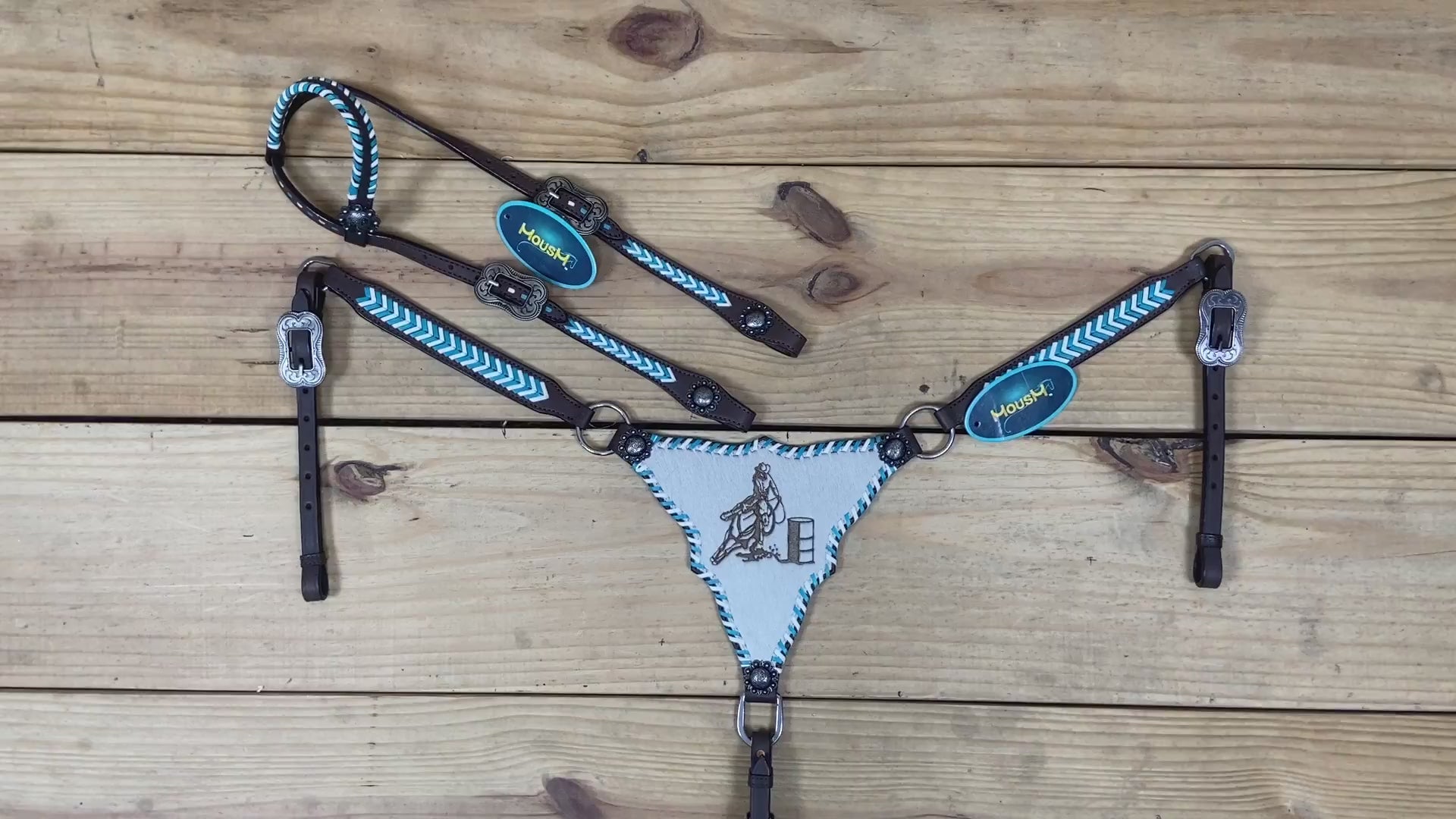 Western horse tack with teal and white rawhide braiding, gladiator style breast collar, and artisan racer engraving details